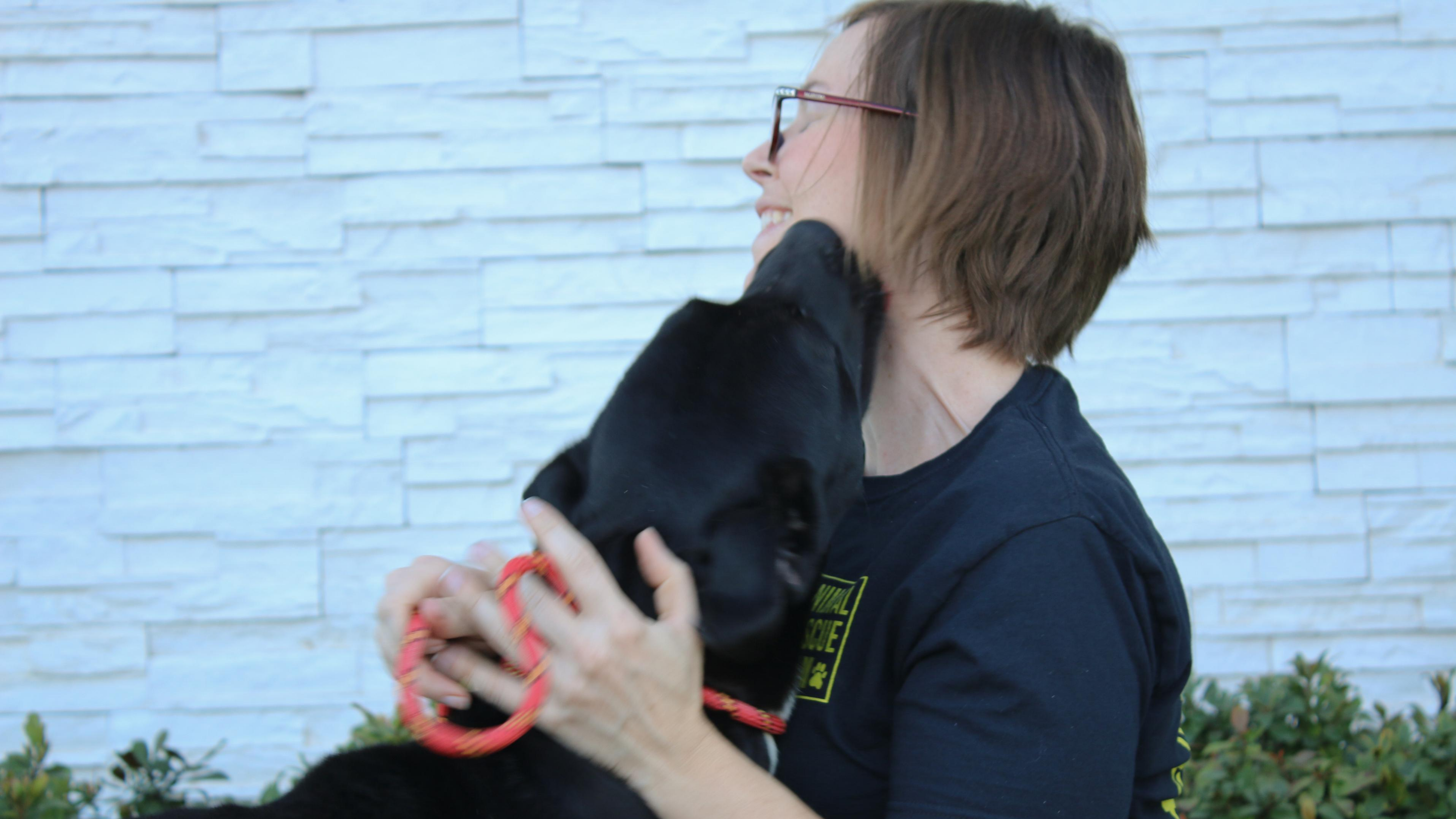 Amy Meyer, our Grassroots Organizer, receives kisses on her face from a rescued dog