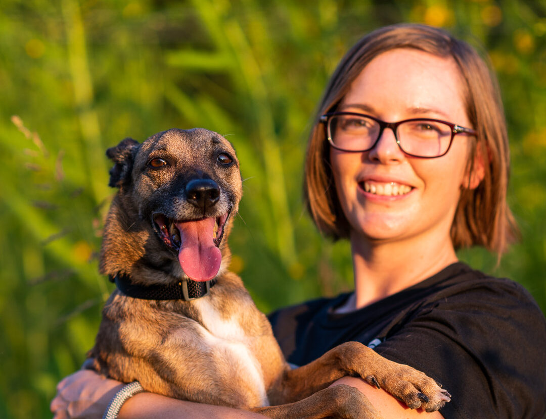 Flakita, a dog rescued by Rise for Animals, looks cheery in the arms of Amy Meyer who smiles