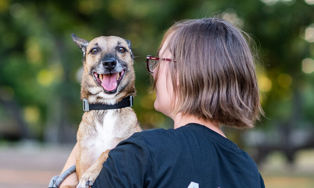 Amy holds Flakita the dog, who smiles widely